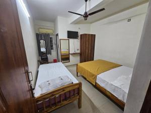 蒂鲁瓦纳马莱Raja Rani Mahal Ac-Rooms的一间卧室配有两张床和吊扇