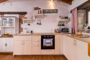 列尔加内斯Casa rural La alemana的厨房配有白色橱柜和烤箱。