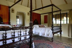 纳纽基欧丽潘基农场山林小屋的一间卧室配有两张带白色床单的床