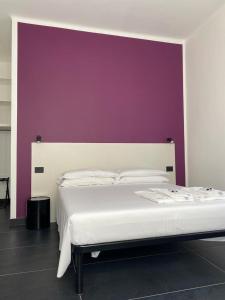 雷卡纳蒂港AMARENA B&B Porto Recanati的卧室配有白色床和紫色墙壁