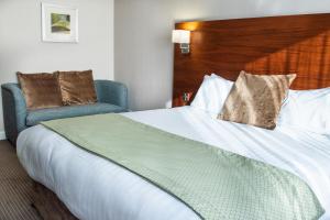 桑德兰Clarion Hotel Newcastle South的酒店客房带一张大床和一把椅子
