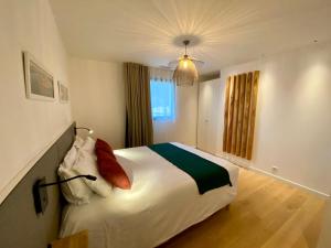 居让梅斯特拉La villa du golf的卧室配有带红色枕头的大型白色床