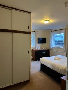 金罗斯The Kinross Salutation Hotel的一间卧室配有一张床、一张书桌和一台电视