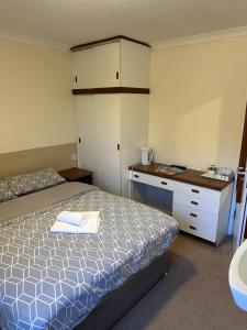 金罗斯The Kinross Salutation Hotel的一间小卧室,配有一张床和一张书桌