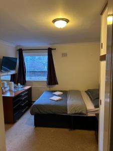 金罗斯The Kinross Salutation Hotel的一间卧室配有一张床、一张书桌和一个窗户。