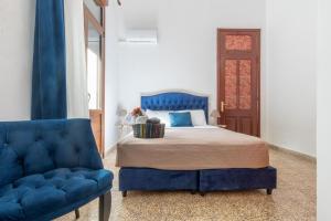 罗德镇mascot traditional guest house的一间卧室配有蓝色的床和蓝色椅子