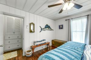 罗克波特Cozy Texas Cottage Less Than 2 Mi to Rockport Beach!的一间卧室配有一张床和吊扇