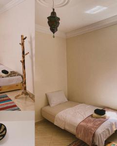 塔姆拉赫特乌兹达尔CHILL SURFER HOSTEL的卧室两张照片,配有一张床和一个吊灯
