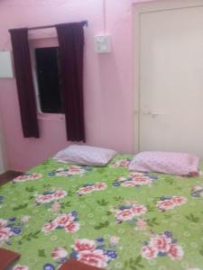 甘帕普拉Sai Laxmi Guest House的一张带绿棉被和鲜花的床
