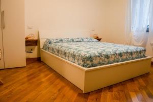 阿尔本加Villa Essenza - Rooms and Breakfast的一间卧室配有一张带花卉棉被的床