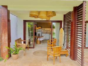 São Gonçalo do AmaranteTaíba Beach Resort por Be My Guest!的一个带椅子的房间,一个位于庭院的冲浪板