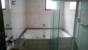 圣保罗北宫酒店的带浴缸和玻璃淋浴间的浴室。