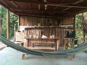 帕洛米诺La Aldea Hostel, Camping y Hamacas的小木屋前的吊床