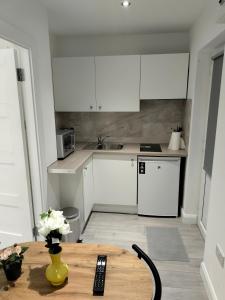 都柏林Oceanik的厨房配有白色橱柜和木桌