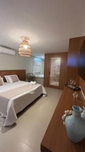 维拉维尔哈提莫内罗旅馆的一间卧室,配有一张床和一张桌子上的花瓶