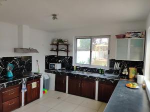 塔科拉迪Beach Road Oasis的厨房配有黑色台面和窗户