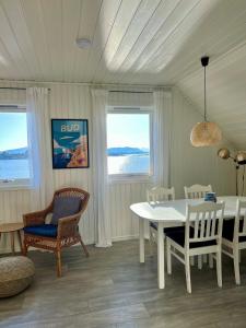 BudWaterfront Rorbu - By the Beach的一间配备有白色桌椅的用餐室