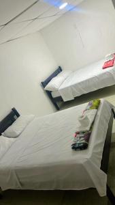 萨利纳斯Bougainville salinas beach的配有2张床的带白色床单和枕头的客房