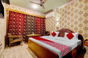 斯利那加Super OYO Mughal Darbar Hotel & Restaurant的一间卧室配有红色枕头的床