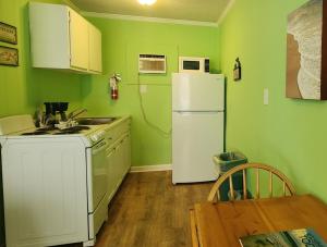 卡罗来纳比奇The Savannah Inn的厨房设有绿色的墙壁和白色的冰箱。
