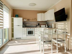 格拉尔-米里茨fewo-ostsee24的厨房配有白色橱柜和桌椅