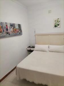 普拉多德尔雷Casa Las Lomas的卧室配有一张床,墙上挂有绘画作品