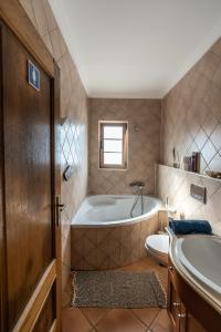 萨格里什Aldeia Caiçara Surf House的带浴缸、卫生间和盥洗盆的浴室