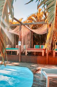 德赛Tropicana Suites的一个带游泳池、吊床和长椅的度假胜地