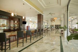 拉纳韦贝Bahia Principe Luxury Runaway Bay - Adults Only All Inclusive的餐厅设有酒吧和桌椅