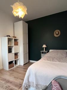 科隆布Le relais des JO 2024的一间卧室设有绿色墙壁和一张床