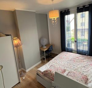 科隆布Le relais des JO 2024的一间卧室设有一张床和一个窗口