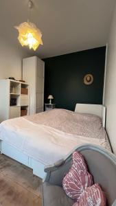 科隆布Le relais des JO 2024的一间卧室设有一张床和绿色的墙壁