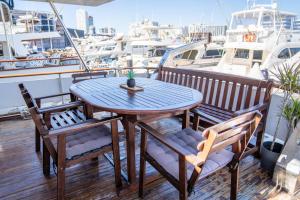 巴塞罗那Boat ALOHA的甲板上配有木桌和椅子,甲板上设有船只