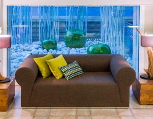 卡里拉KAKTUS Hotel Kaktus Playa - Adults Recommended的客厅配有带枕头的沙发,设有水族馆