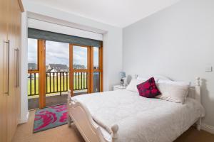 TermonbarryShannonside - Stylish 5 Bed Marina home & 40ft mooring的一间白色卧室,配有床和阳台