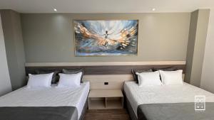 波帕扬M A Hotel的墙上画画的房间里设有两张床