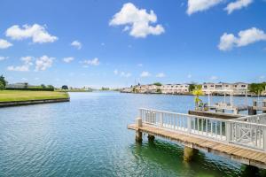 BolansTrue North - Waterfront Villa, Jolly Harbour的河上码头,有房子的背景