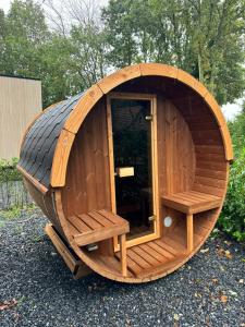 哈尔德韦克Kindvriendelijk luxe chalet in de bossen met privé sauna的一座大型木制圆形建筑,里面设有长椅