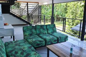 Hone CreekBlue Dreams Hotel的一张绿色沙发,位于带桌子的阳台