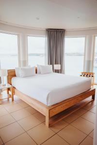 维拉港格兰德酒店及赌场的卧室在窗户前配有一张白色大床