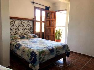 希利特拉Hotel Posada San Agustin的一间带床的卧室,位于带窗户的房间内