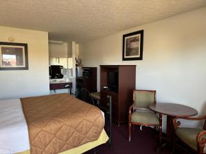 AlbanyRoyal Inn的配有一张床、一张桌子和一张桌子的酒店客房