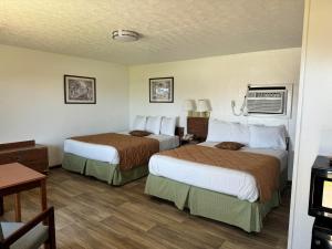 AlbanyRoyal Inn的酒店客房设有两张床和一张桌子。