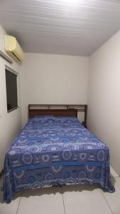 帕尔马斯Cozy的一间卧室配有一张带蓝色棉被的床