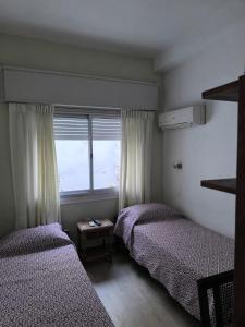 派桑杜洛巴托酒店的带窗户的客房内的两张床