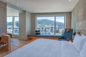 基多GO Quito Hotel的一间卧室设有一张床和一个大窗户