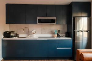 墨西哥城Casa Serenos的厨房配有蓝色橱柜和冰箱。