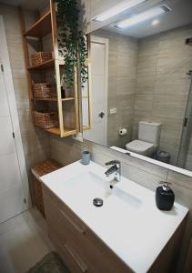 洛斯克里斯蒂亚诺斯Sun Apartment Cristimar (3 bedrooms)的一间带水槽、镜子和卫生间的浴室