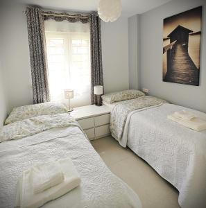 洛斯克里斯蒂亚诺斯Sun Apartment Cristimar (3 bedrooms)的一间卧室设有两张床和窗户。