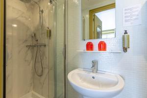 巴黎黄金酒店的一间带水槽和淋浴的浴室